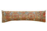 Antique Belouch fragment lumbar pillow, geometric patterns in aged tan, blue, and coral.