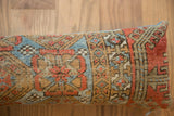 Patinaed terracotta and blue geometric motifs on the antique Belouch fragment pillow.