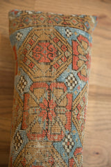 Vibrant geometric pattern of the antique Belouch fragment in earthy brown, terracotta, and blue.