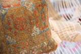 Patinaed texture and geometric motifs on an antique Belouch rug fragment pillow.