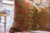 Antique Belouch rug fragment pillow, showing distressed geometric pattern and aged pile.