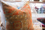 Antique Belouch pillow with hand-knotted texture, geometric patterns in terracotta, olive, and faded blue.