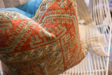 Antique Belouch pillow: rust geometric pattern with muted tones and blue fabric.