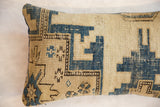 Geometric blue and beige pattern with distressed texture on a vintage Caucasian rug pillow.