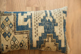 Hand-knotted vintage Caucasian pillow showing cream and indigo geometric motifs and textured weave.
