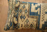 Vintage Caucasian rug pillow with blue and cream geometric motifs, textured weave.