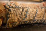 Angled detail of the vintage Caucasian rug pillow's textured beige, blue, and brown geometric pattern.