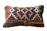 Vibrant vintage rug fragment pillow with geometric motifs in blue, orange, ivory, and burgundy, 9x15 inches.