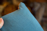 Vintage rug pillow's deep blue-green backing, showcasing its fine ribbed texture.