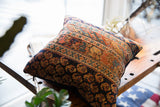 Antique Afshar fragment pillow: intricate tribal motifs in banded terracotta, navy, and gold.