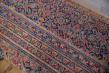 Close-up of Vintage Persian Rug Ottoman's intricate navy, faded red, gold patterns.