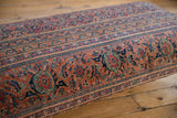 Vintage Persian rug ottoman side, intricate curvilinear borders in navy, faded red, gold.