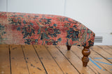 Vintage Persian Rug Ottoman detail: worn rose red, navy fragment, visible foundation, curved leg.
