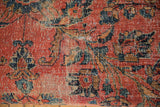 Patinaed vintage Persian rug fragment close-up; rose red, navy, gold floral motifs.
