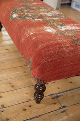Distressed, finely woven Malayer rug fragment brick red, teal, cream on antique coffee table side.