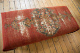 Antique Malayer rug fragment surface with faded geometric patterns and visible repairs.