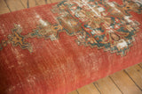 Finely woven Malayer rug fragment with faded red, teal, gold pattern, visible cotton foundation.