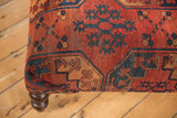 Corner of the antique Ersari rug fragment ottoman with bold red and navy tribal motifs.