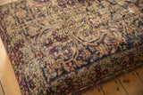 Antique Kerman rug fragment ottoman edge, showing worn traditional pattern, beige, red, and blue.