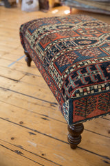 Geometric pattern detail on the vintage Northwest Persian rug fragment ottoman in navy, rust, and teal.