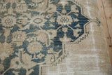 Detail of antique Persian Doroksh fragment: worn dusty navy pattern over visible beige foundation.