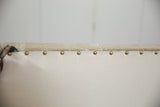 Brass studs, cotton canvas trim of ottoman, showing circa 1920s Persian rug fragment.