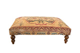 Antique Persian Kerman rug fragment ottoman table with ivory, red, and navy dragon and lantern motifs.