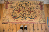 Overhead view of Antique Kerman rug fragment ottoman top, with red lantern and floral motifs.