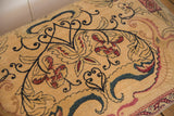 Intricate cochineal red, navy, and beige floral design on an antique Kerman rug fragment.