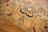 Worn pile and visible foundation on an antique Kerman rug fragment with red accents.