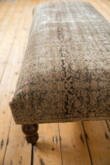 Close-up of the Vintage Rug Fragment Ottoman Table's distressed beige and charcoal rug surface.