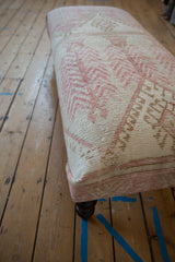 Side view of vintage distressed Oushak ottoman showcasing blush and ivory geometric pattern.