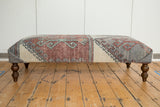 Unique vintage rug fragment ottoman table with distressed geometric layout in rust, gray, and cream.
