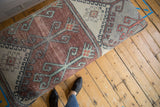 Distressed vintage Turkish rug fragment detail, featuring muted rust, time-softened grey, and mint motifs.