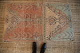 Distressed vintage Turkish rug fragment ottoman top, with unique peach and teal geometric design.
