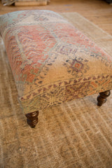 Distressed vintage Oushak rug fragment side with subdued neutral pattern and dark turned leg.