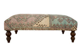 Vintage Oushak rug ottoman table, featuring distressed geometric patterns in ivory, turquoise, lavender.