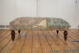 Side view, vintage Oushak rug ottoman with distressed Turkish geometric pattern in faded turquoise, lavender.