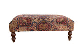 Antique Rug Fragment Ottoman Table, Persian Kerman pattern in beige, red, blue, with turned legs.