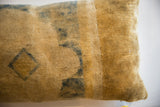 Textured close-up of the antique Chinese rug fragment pillow, with faded indigo geometric motifs.