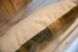 Side detail of the reclaimed Chinese rug fragment pillow, showing cream canvas and rich, variegated pile.