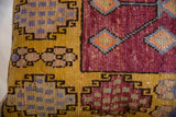 Vibrant geometric plum, golden yellow, and blue pattern on Oushak rug fragment pillow.