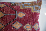 Maroon, blue, and orange geometric zig-zag pattern detail on the vintage Oushak pillow.