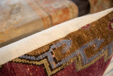 Vintage Oushak fragment pillow close-up: rich wool texture, geometric red and blue pattern.