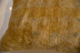 Antique Chinese rug fragment pillow's soft gold pile, revealing visible wear and texture.