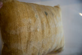 Close detail of antique Chinese rug fragment showing golden pile and age patina.