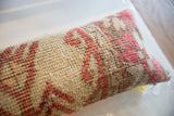 Close-up of vintage Oushak lumbar pillow, featuring hand-knotted texture with muted coral and cream patterns.