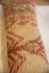 Textured close-up of vintage Oushak rug fragment, with beige and muted red geometric patterns.