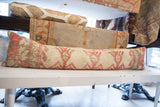 Side view of vintage Oushak lumbar pillow with textured coral and cream geometric pattern.