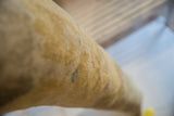 Plush, muted yellow pile of the antique Chinese lumbar pillow, displaying subtle blue-grey variation.